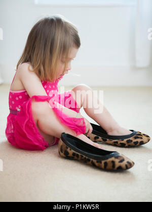 Young girl trying on her mums accessories. Stock Photo