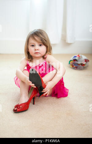 Young girl trying on her mums accessories. Stock Photo