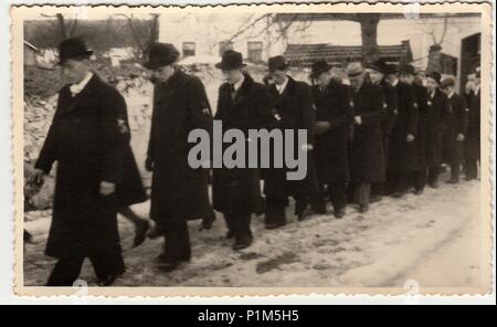 THE CZECHOSLOVAK REPUBLIC - CIRCA 1930s: Vintage photo shows crowd of men during winter time. Black & white antique photography. Stock Photo