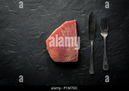 Raw Tuna Steak on Dark Stone Background Stock Photo