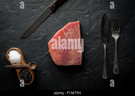 Raw Tuna Steak on Dark Stone Background Stock Photo