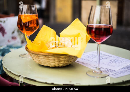 wine glasses on bistro table outside with potato chips Stock Photo