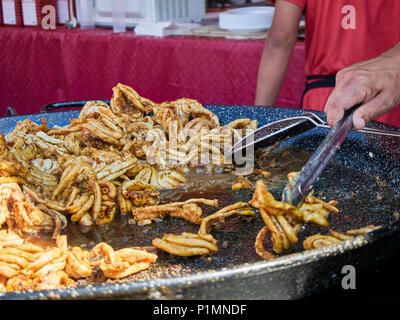 Cook frying Gallinejas (Lamb Mesentery) in a stall of a Street Food fair. Stock Photo