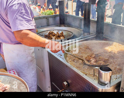 Cook frying Entresijos (Lamb Mesentery) in a stall of a Street Food fair. Stock Photo