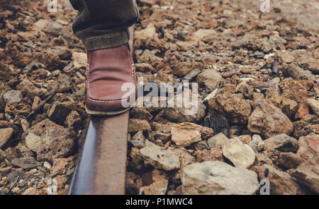 Foot on the rail of the train track, on the stone floor in the old station of Zaranda, Spain Stock Photo