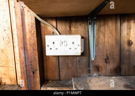 Very old electricity plug sockets in an old shed Stock Photo