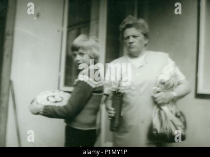 THE CZECHOSLOVAK SOCIALIST REPUBLIC - 1959:  Retro photo shows mother and her son in the backyard.  Vintage black & white photography. Note: blurriness, better at smaller sizes. Stock Photo