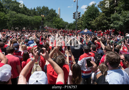 Washington, DC, USA.  12th June, 2018.  Stanley Cup with Washington Capitals hockey team players (on bus) pass some of the tens of thousands fans lining Constitution Avenue as procession made it way to he National Mall for an afternoon rally celebrating the Cap’s victory over the Vegas Golden Knights for their first ever Stanley Cup. Bob Korn/Alamy Live News Stock Photo