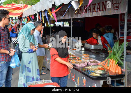 Bandar Seri Begawan, Brunei. 12th June, 2018. People choose and buy local delicacies at a Ramadan market in Bandar Seri Begawan, capital of Brunei, June 12, 2018. Brunei's local markets witnessed booming business in the month of Ramadan. Credit: Jeffrey Wong/Xinhua/Alamy Live News Stock Photo