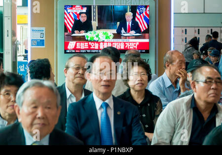Summit between the U.S. and North Korea, June 12, 2018 : People at the Seoul station in Seoul, South Korea watch TV news report on the U.S. President Donald Trump meeting with North Korean leader Kim Jong-Un during their summit in Singapore. Kim reaffirmed his commitment to the 'complete denuclearization of the Korean Peninsula' in a written agreement with Trump, local media reported. Credit: Lee Jae-Won/AFLO/Alamy Live News Stock Photo