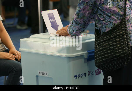 Seoul, South Korea. 13th June, 2018. A voter casts her ballot at a polling station in Seoul, South Korea, June 13, 2018. South Korean people began voting early Wednesday in local elections and parliamentary by-elections in what appeared to be a confidence vote on the government of President Moon Jae-in. Credit: Wang Jingqiang/Xinhua/Alamy Live News Stock Photo