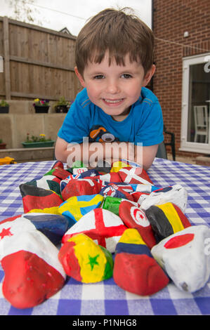 Greater Manchester, UK. 13th June 2018. Three year old Luke Wilkinson of Mossley, Greater Manchester, England shows off his collection of hand-painted rocks, (with a little help from Dad!) all in the colours of the competing nations of the upcoming FIFA World Cup. Credit: Matthew Wilkinson/Alamy Live News Stock Photo