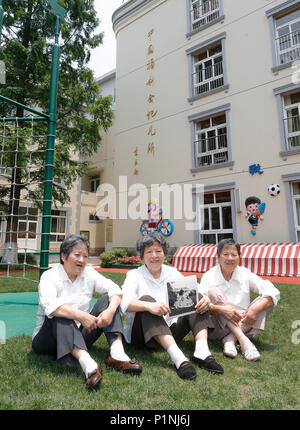 (180613) -- SHANGHAI, June 13, 2018 (Xinhua) -- Triplets Xu Manzhen (L), Xu Manying (C) and Xu Manjing pose with their childhood photo at the China Welfare Institute (CWI) Nursery in Shanghai, east China, June 12, 2018. This year marks the 80th anniversary of CWI, founded by Soong Ching Ling in 1938. The Shanghai-based organization focuses on maternal and child health, education and social welfare. Soong Ching Ling, born in Shanghai in 1893, was the wife of Chinese revolutionary Dr. Sun Yat-sen, who led the 1911 Revolution.  (Xinhua/Gao Feng) (wyl) Stock Photo