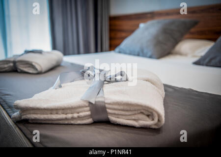 Bathrobe on bed in hotel room Stock Photo