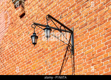 Vintage decorative lantern hanging on an old brick wall Stock Photo