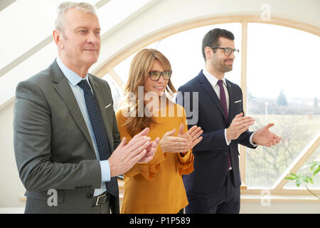 Group of business people applauding while celebrating successfull business. Stock Photo