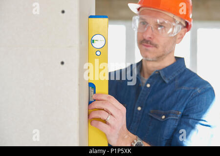 Clsoe-up of handyman using spirit level while working on construction site. Stock Photo