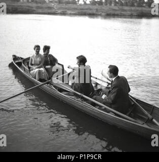 1955, historical, courting?..... two well-dressed young adult couples on the River Thames in a rowning boat at Teddington, Surrey, England, UK. Stock Photo