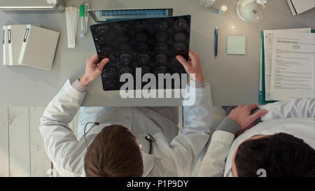 Doctors  team having a discussion and review a magnetic resonance imaging. Top view Stock Photo