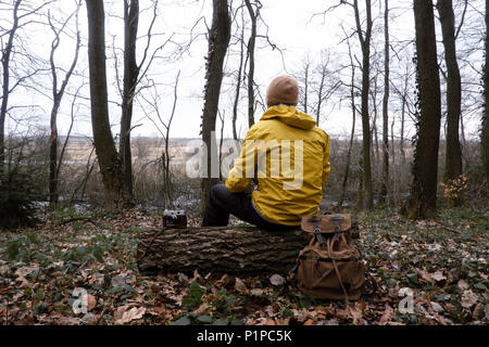 Man with backpack in wild forest Stock Photo