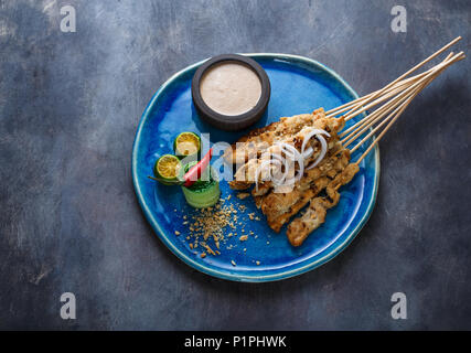 Satay ayam or malaysian meat skewers with peanut saucem copyspace. Stock Photo
