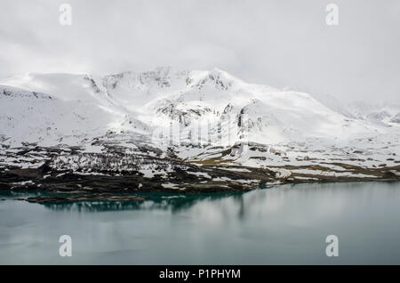 Col du Mont Cenis, Lake du Mont Cenis with snowy peak in background; Savoie, France Stock Photo