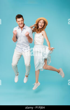 Image of young excited caucasian people man and woman jumping isolated over blue background make winner gesture screaming. Stock Photo