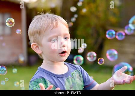 Boy playing with bubbles Stock Photo