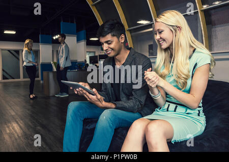 Young millennial business professionals in the workplace collaborating and using technology; Sherwood Park, Alberta, Canada Stock Photo