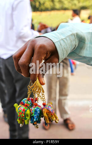 Close-up of a hand holding handmade key chains at the small market outside Taj Mahal, Agra, Uttar Pradesh, India. Agra is one of the most populous cit Stock Photo