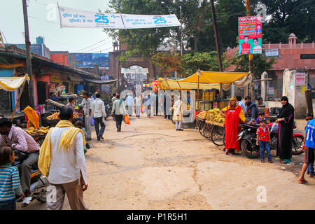 Local people walking through street market in Fatehpur Sikri, Uttar Pradesh, India. The city was founded in 1569 by the Mughal Emperor Akbar, and serv Stock Photo