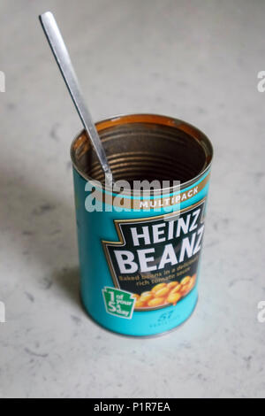 Empty opened multipack tin of Heinz Beanz, a popular brand of baked beans in tomato sauce, with handle of a spoon or fork sticking out the top Stock Photo