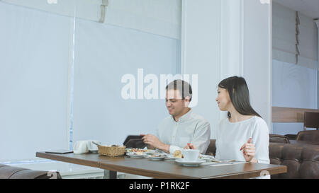 Happy couple paying bill brought by waiter and leaving cafe Stock Photo