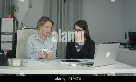 Senior manager giving salary in cash to new employee Stock Photo