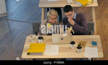 Workers enjoying lunch break in the office Stock Photo