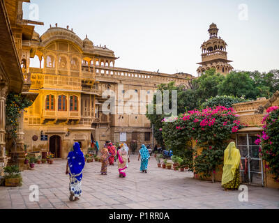 Indian women walking in colourful saris in a town square; Jaisalmer, Rajasthan, India Stock Photo