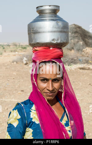 A woman carrying a jug on her head; Jaisalmer, Rajasthan, India Stock Photo