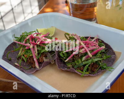 Two carne asada tacos sitting on restaurant table in a tropical setting Stock Photo