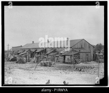 'We give them houses to live in,' About 50 persons housed in this miserable row of dilapidated shacks. Located on an old shell-pile and partly surrounded by a tidal marsh. Maggioni Canning LOC nc 0073 Stock Photo