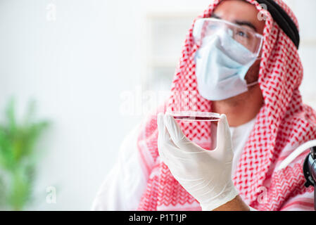 Arab doctor chemist studying new virus in lab Stock Photo