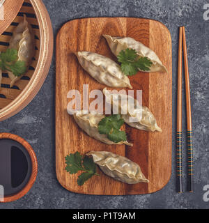 Fresh dumplings on a dark stone background. Asian cuisine, top view, copy space. Stock Photo