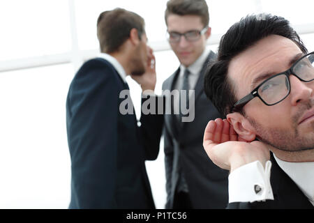 close up.businessman eavesdropping on conversation between colleagues Stock Photo