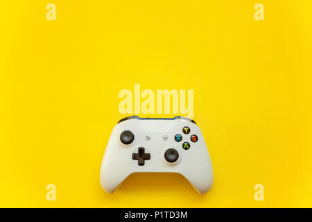 SAINT-PETERSBURG, RUSSIA - APRIL 13, 2018: White joystick xbox one s gamepad, game console on yellow background. Computer gaming competition videogame Stock Photo