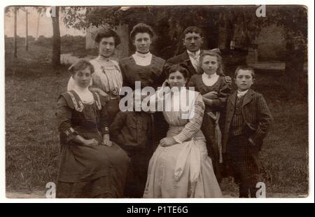 BURGSTADT, GERMANY - CIRCA 1920s: Vintage photo shows people pose in the garden. Women with Edwardian hairstyles. Retro black & white photography. Stock Photo