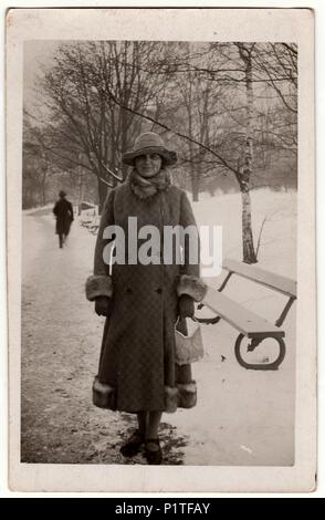 THE CZECHOSLOVAK REPUBLIC - CIRCA 1940s: Vintage photo shows woman in a winter time. Woman wears a long coat with fur bordering.  Retro black & white photography. Stock Photo