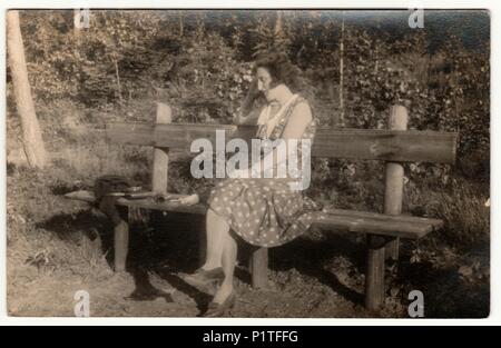 THE CZECHOSLOVAK REPUBLIC - JUNE 26, 1931: Vintage photo shows woman sits on the wooden bench in the park. Retro black & white photography. Stock Photo