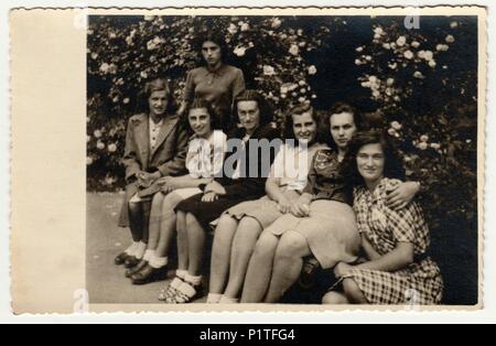 THE CZECHOSLOVAK REPUBLIC - CIRCA 1940s: Vintage photo shows a group of girls poses outdoor. Retro black & white photography. Stock Photo