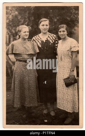 THE CZECHOSLOVAK REPUBLIC -  CIRCA 1940s: Vintage photo shows three mature woman poses outdoors. Retro black & white photography. Stock Photo