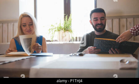 Happy caucasian couple takes the menu at the cafe Stock Photo