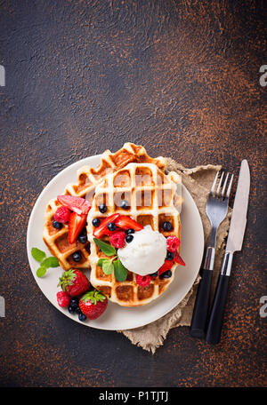 Delicious Belgian waffles with ice cream, berries and chocolate sauce ...